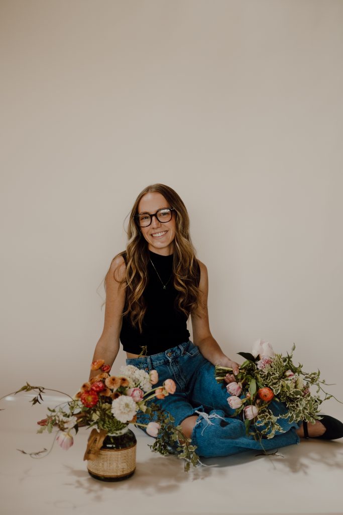 a woman sitting on the floor with flowers