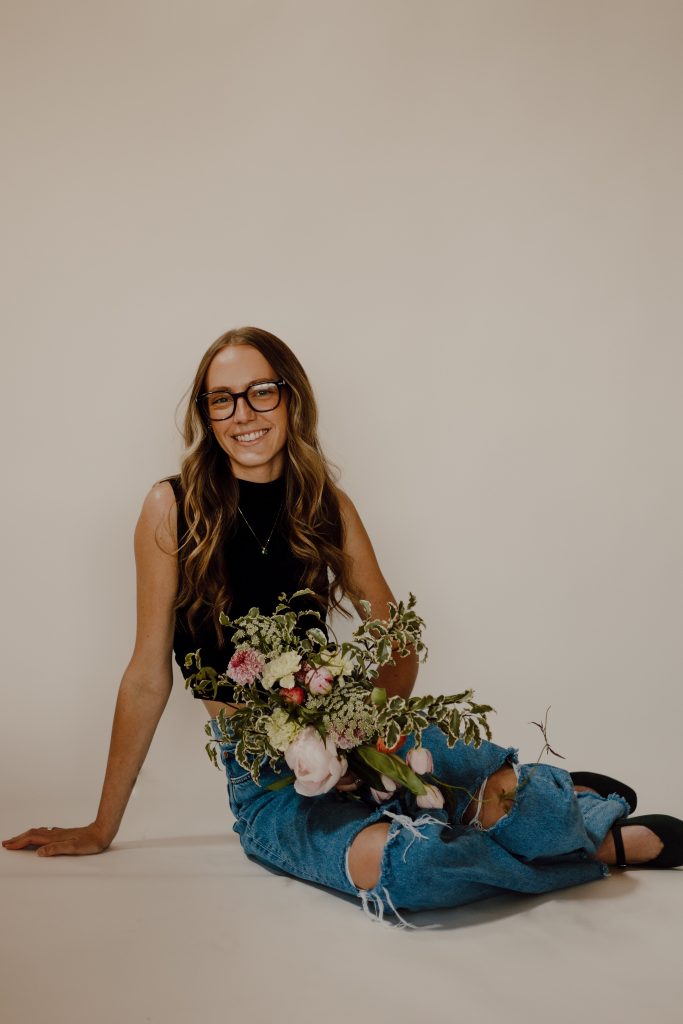 a woman sitting on the floor with flowers