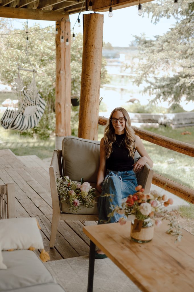 a woman sitting on a chair on a porch
